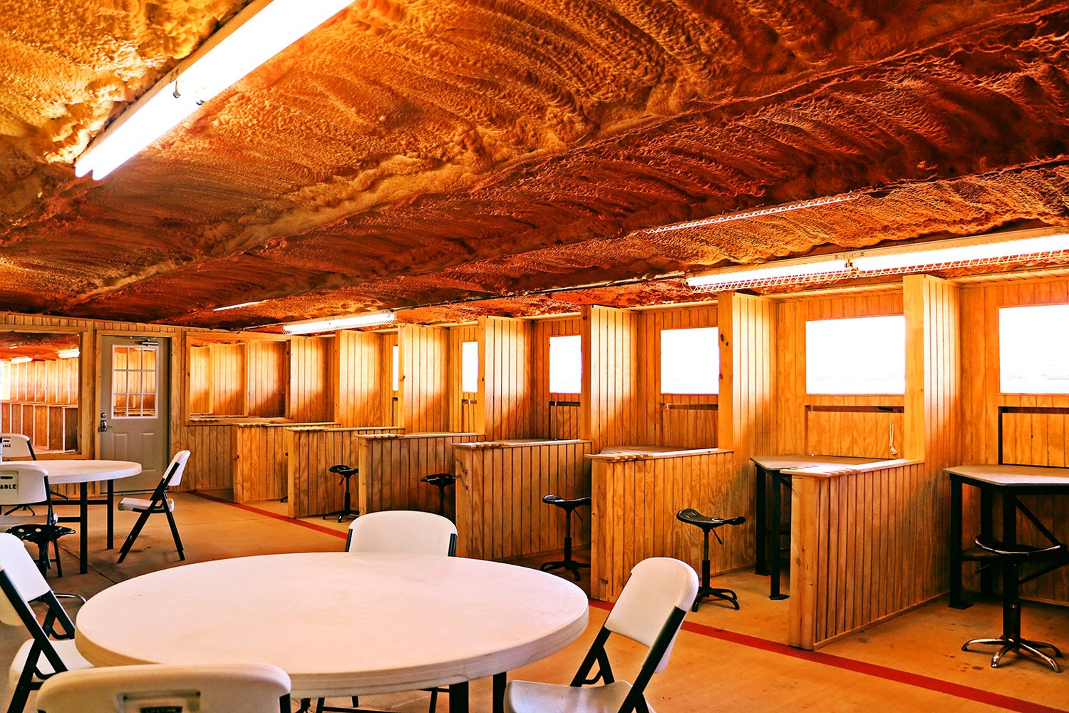 Covered rifle and pistol shooting stations with tables and stools