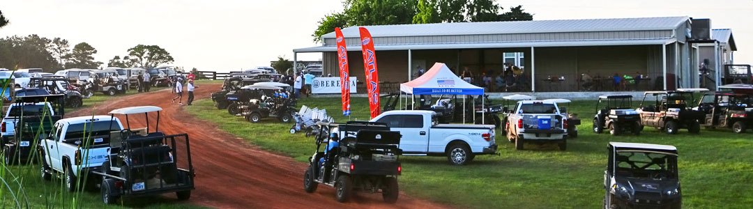 Golf carts and trucks gathered outside the pavilion during a tournament at Able's Gun Club